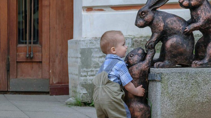 Мальчик помогает крольчонку